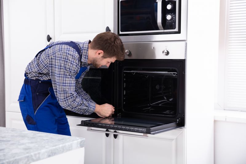 Appliance Repair Technician inspecting an oven