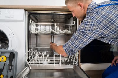 Technician repairing a dishwasher